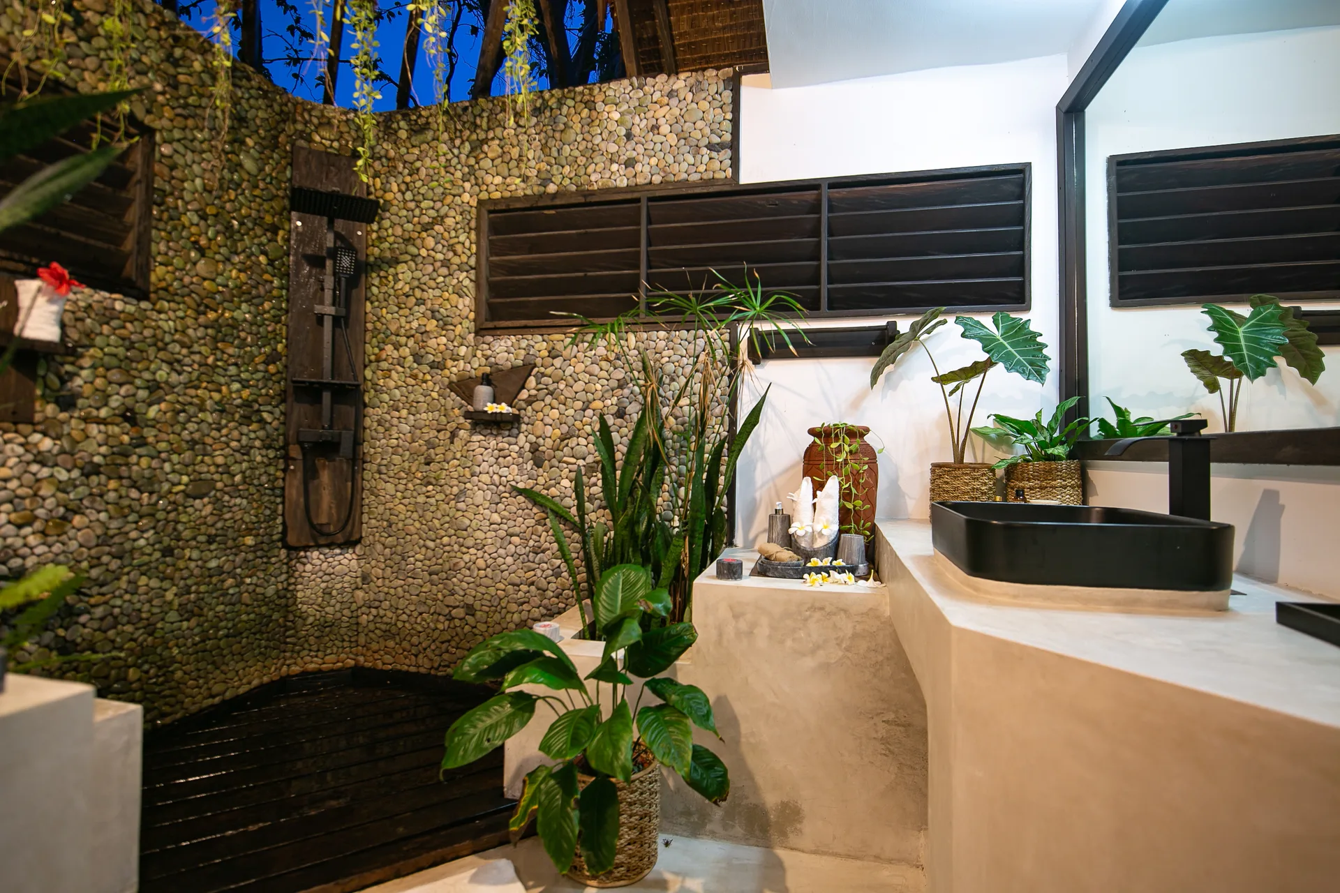 Bathroom side view with tropical plants and polished concrete vanity — Kawayan Villa private villa