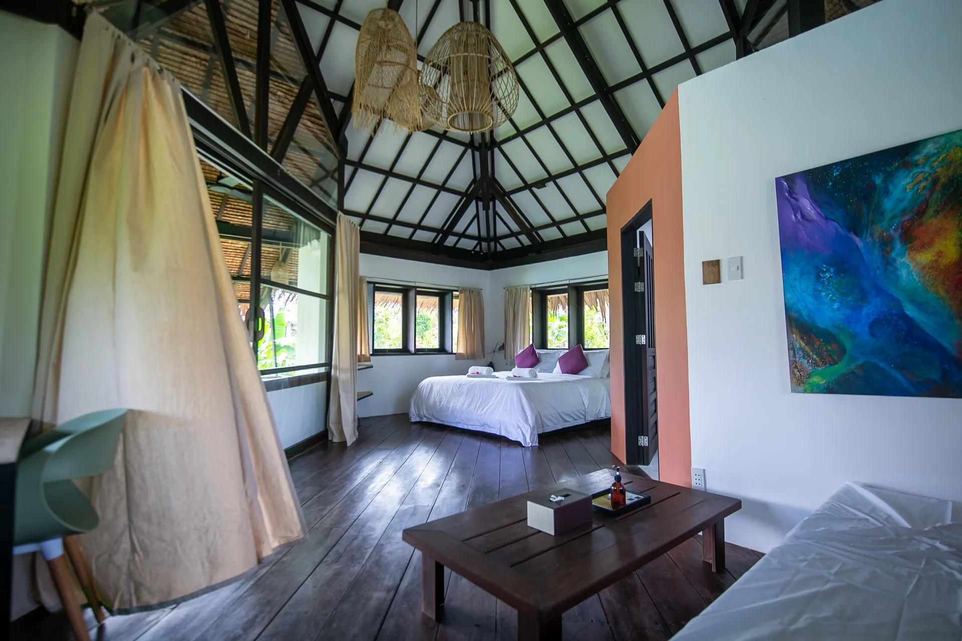 Bedroom interior with cathedral ceiling, king bed and tropical artwork — Kawayan Villa Siargao