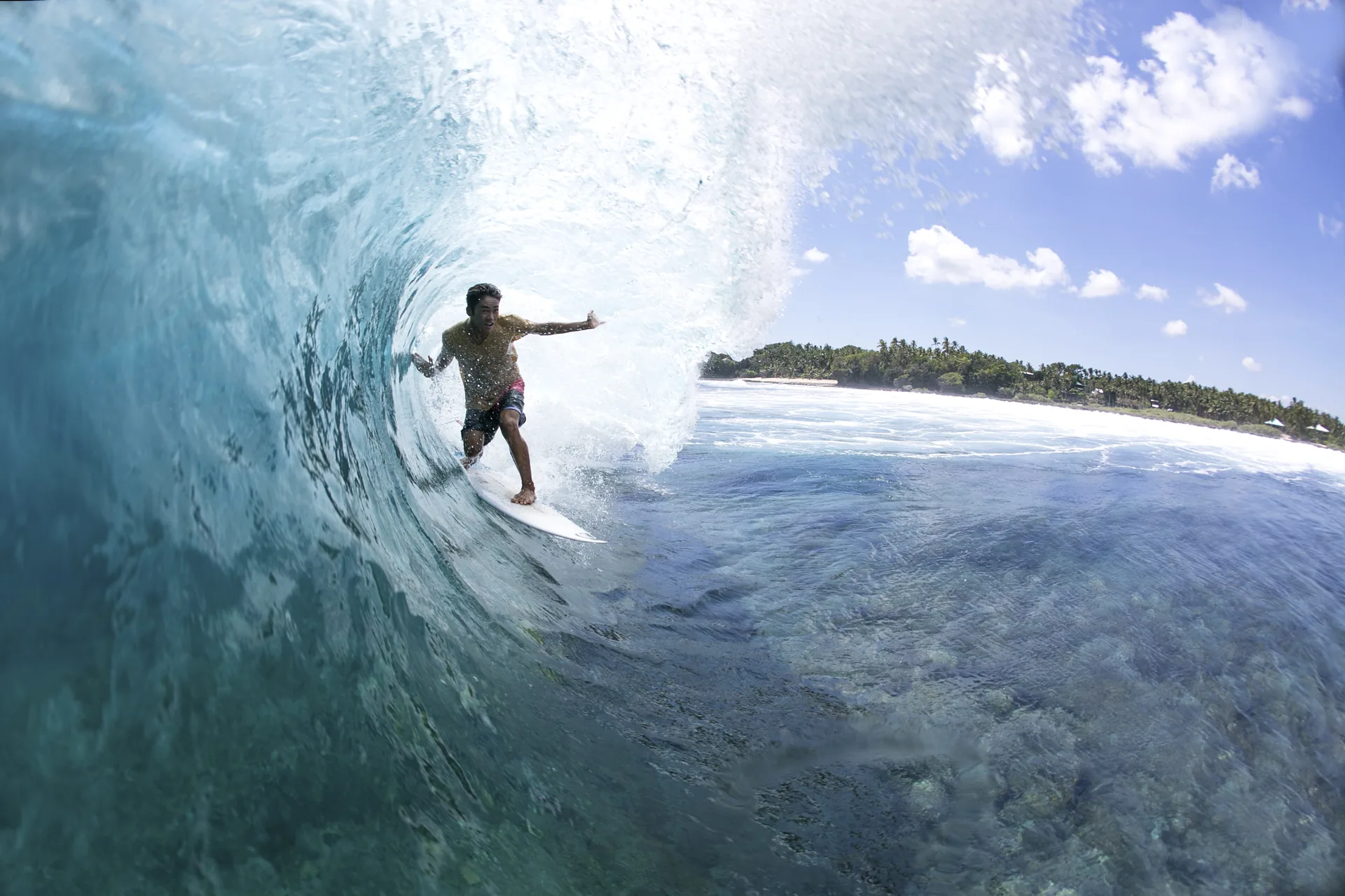 Surfer with arm extended inside a Cloud 9 barrel, Siargao