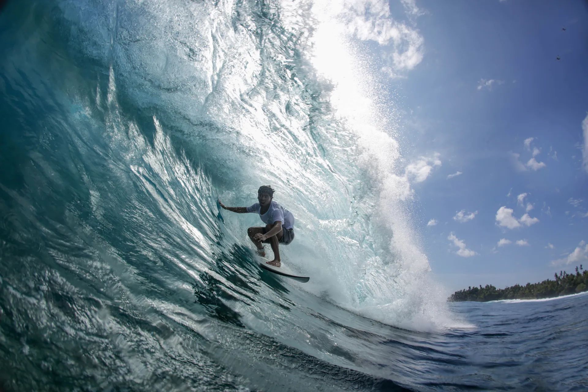 Surfer in a tropical Cloud 9 barrel — beginner surf lessons Siargao at Kawayan Villa