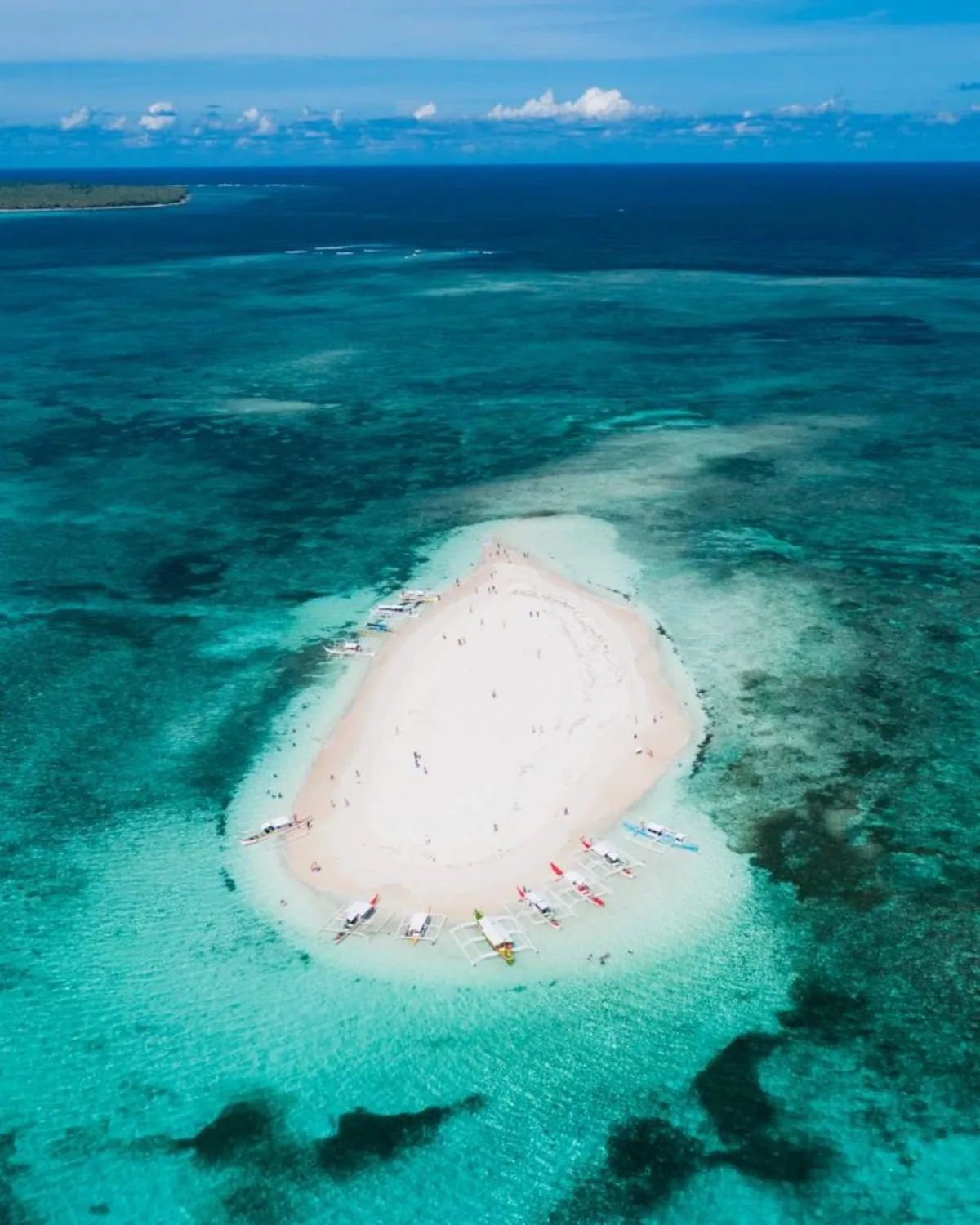Aerial view of Naked Island, Siargao — a bare white sandbar surrounded by turquoise water, the classic island-hopping stop